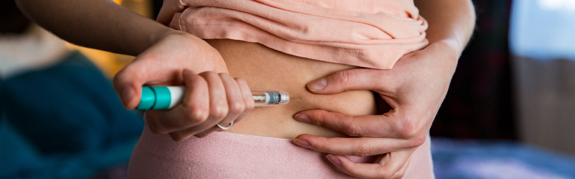 Woman making hormonal therapy injection into her belly